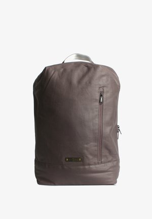 Zaino in pelle marrone con una texture liscia, una tasca laterale con zip e una maniglia superiore. Presenta un logo discreto e un design semplice.