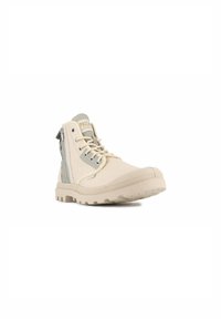 Bottines beiges à finition texturée, avec des accents gris, un laçage à l'avant et une fermeture éclair sur le côté pour un enfilage facile. Semelle en caoutchouc pour une bonne adhérence.