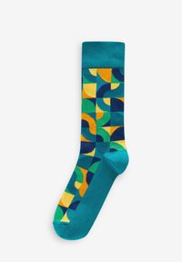 Chaussettes turquoise présentant un motif géométrique en vert, jaune et bleu marine. Texture lisse avec des couleurs et des formes contrastées.