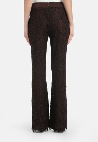 Bruine flared broek met een textuur van een bloemmotief, voorzien van een gladde tailleband en een ritsluiting aan de achterkant.