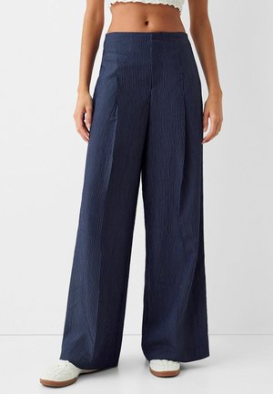 Marineblauwe broek met wijde pijpen en verticale witte strepen, met een hoge taille, plooien en een gestructureerd stofdesign.