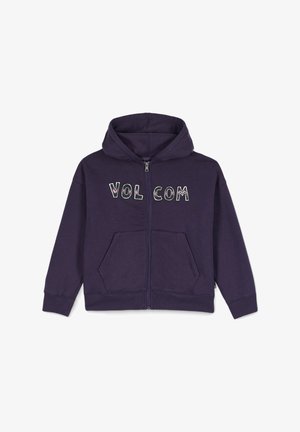Sudadera morada con cremallera y bolsillos frontales, con el texto "VOL COM" en blanco y acentos florales. Fabricada en un suave tejido texturizado.