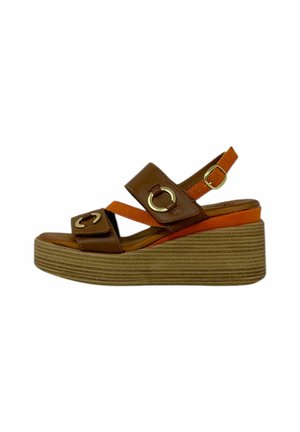 Sandali con zeppa in pelle marrone con dettagli arancioni, dotati di cinture larghe e accessori circolari in oro. La suola testurizzata offre aderenza.