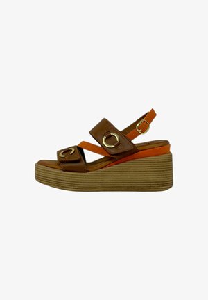 Sandali con zeppa in pelle marrone con dettagli arancioni, dotati di cinture larghe e accessori circolari in oro. La suola testurizzata offre aderenza.