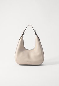 Sac hobo beige en cuir texturé, présentant une forme courbée, une seule bandoulière et des ferrures en métal argenté avec un logo en relief à l'avant.