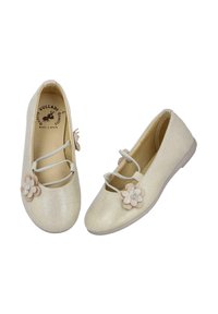 Bailarinas metálicas doradas con punta redonda, que presentan dos correas elásticas y un adorno de flor de encaje en la punta. Forro interior suave.