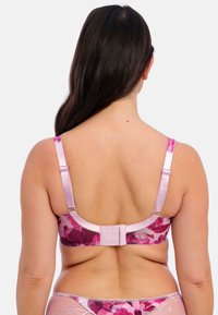 Floral-patterned pink bra with adjustable straps, hook-and-eye closure, and smooth texture. Back view highlights design and craftsmanship.