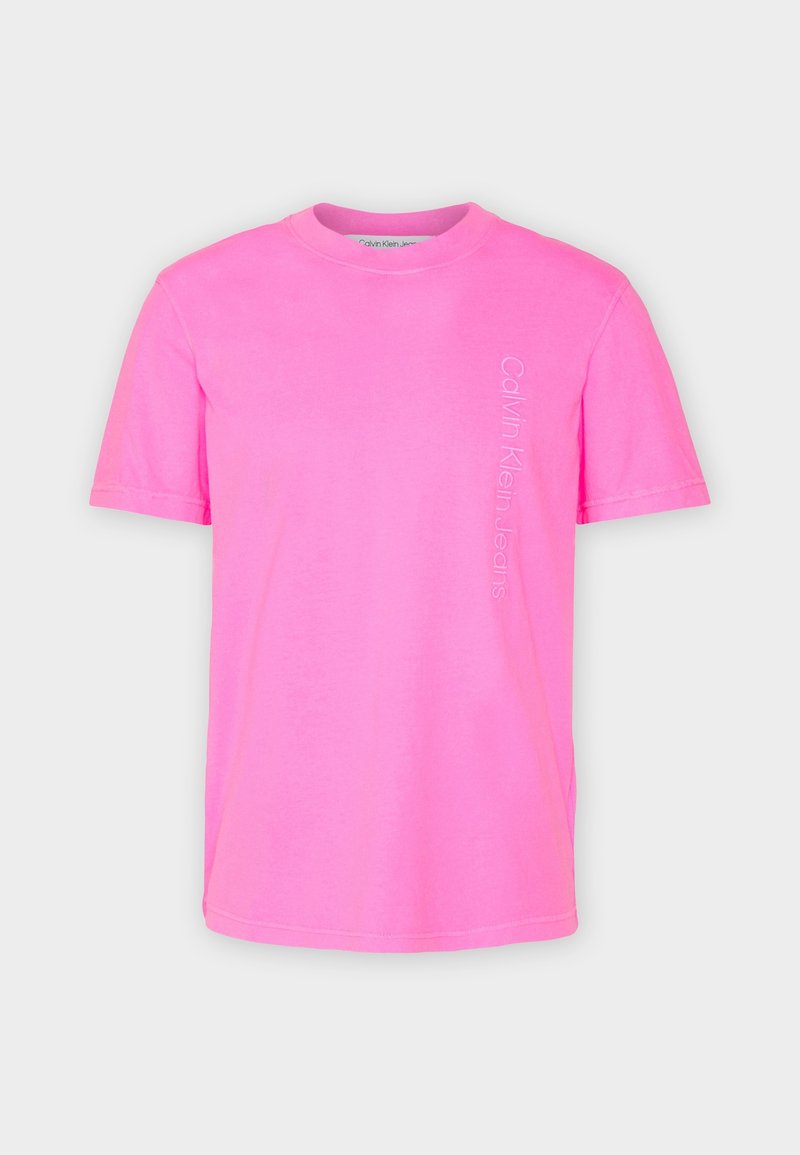 Pink cotton T-shirt with short sleeves, round neckline, and "Calvin Klein Jeans" logo printed vertically in white on the front left side.