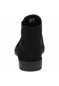 Bota de ante negra hasta el tobillo con un tacón bajo y plano. Presenta cortes laterales y una textura suave. Diseño simple, sin patrones visibles ni hardware.