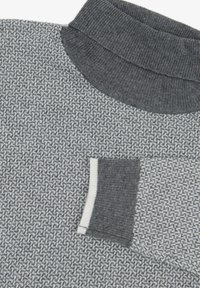 Strickpullover mit hohem Kragen, der ein grau-weißes strukturiertes Muster, gerippte Ärmelbündchen und ein kontrastierendes Taschen-Detail aufweist.