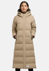 Lange beige pufferjas met een capuchon, voorzien van horizontale gestikte secties, ritszakken aan de zijkanten en een wit logo-label dichtbij de zoom.
