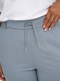 Light blue elastic waistband pants with a drawstring closure, featuring silver metal accents and a smooth, textured fabric.