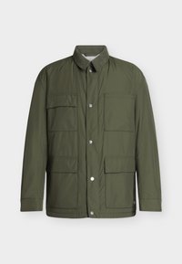 Veste légère verte avec fermeture à boutons, quatre poches frontales et un col court, présentée sur un fond uni.