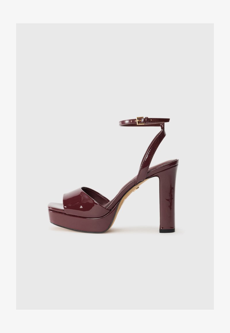 Sandal de charol burdeos de tacón alto con plataforma, tira para el tobillo y detalle de hebilla dorada. Diseño elegante y acabado brillante.