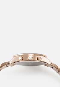 Montre en métal doré rose avec un boîtier rond, deux boutons-poussoirs et un bracelet à maillons texturé. Dotée d'un cadran noir et d'un détail logo.