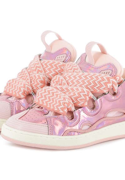Rozā metāla sporta apavi ar tekstūrētām rozā zolēm, biezām chevron raksta šņorēm un iegriezumiem sānos gaisa cirkulācijai.