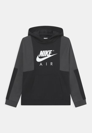 Sudadera con capucha negra con bolsillo canguro, paneles laterales grises contrastantes y un logotipo blanco de Nike Air en el frente. Textura de tela suave.