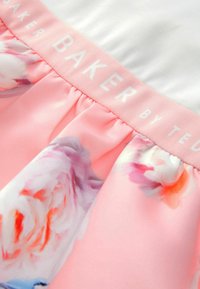 Rosa Blumenrock mit satinierter Oberfläche und gerafftem Design. Der Taillenbund enthält das geprägte Logo "BAKER by TED."