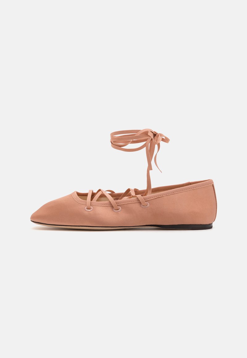 Bailarinas de satén color rosa claro con punta afilada, que presentan cordones entrecruzados y lazos en el tobillo. Textura suave y suela plana.