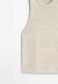 Haut sans manches en maille de couleur beige clair, doté d'un col arrondi et d'une finition lisse et texturée. Les bords sont soigneusement finis.