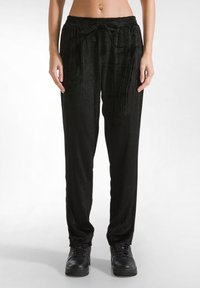 Zwarte, geribbelde velours broek met een elastische tailleband en trekkoord. Losse pasvorm, met zijzakken en een gladde textuur.