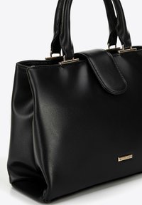 Bolso de mano de cuero negro con forma estructurada, asas dobles, cierre magnético en la solapa y acento de logo en dorado. Textura suave.