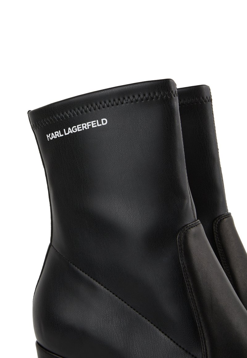 Zwarte leren enkellaarzen met een naadloos ontwerp, voorzien van een contrasterend paneel, gestikte accenten en het "KARL LAGERFELD" logo op de schacht.