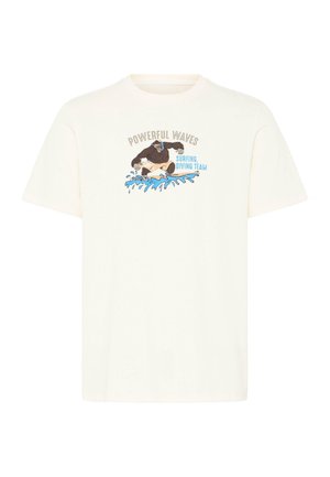 T-shirt beige avec un graphisme d'un gorille surfant sur des vagues bleues, texte au-dessus et à côté indiquant "POWERFUL WAVES Surfing, Diving Team."