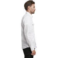 Camicia bianca a maniche lunghe con colletto button-down, una tasca sul petto e design aderente, indossata con pantaloni scuri. Tessuto liscio e stoffa fresca.