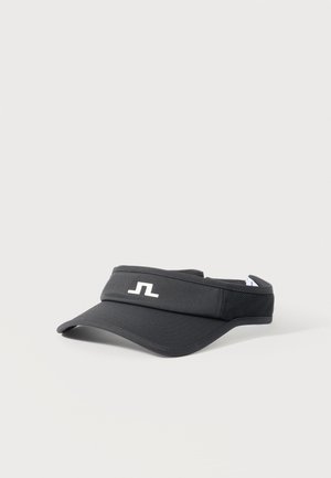 Visière de sport noire à visière incurvée avec un logo stylisé blanc à l'avant, posée sur un fond gris clair uni.