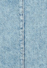 Light blue denim fabric with a vertical seam running down the center, showing texture and stitching details.
