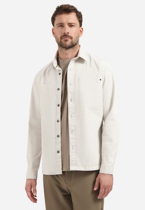 Lichtbeige overhemd met knopen, gemaakt van katoen, met twee borstzakken, lange mouwen en een relaxte pasvorm. Het overhemd heeft grijze knopen.