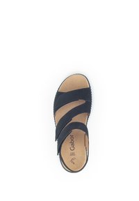 Black suede sandal with three crossed straps and a cushioned beige insole. Textured rubber outsole provides grip and stability.