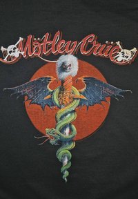 Svart grafisk T-skjorte med et sentralt design av et sverd, en grønn slange og vinger, omgitt av en oransje sirkel og teksten "Mötley Crüe".
