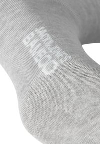Chaussette grise en tissu doux et texturé, présentant un texte imprimé blanc sur le côté. Le design est lisse et sans couture, mettant en avant le confort.