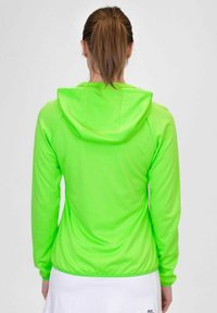 Felpa verde neon con maniche lunghe e cappuccio sul retro. Tessuto liscio e design aderente. Tessuto leggero con una leggera lucentezza.