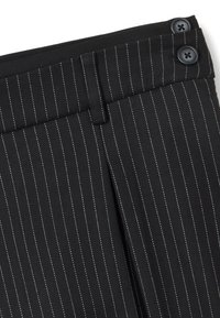 Pantalones negros de rayas con rayas blancas, con una textura suave, pliegues delanteros y dos grandes botones negros en la cinturilla.