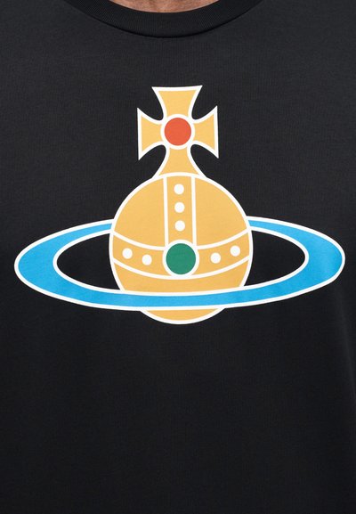 Μαύρο μπλουζάκι με μεγάλο γραφικό ενός χρυσού σφαίρας με σταυρό, περιβαλλόμενο από μπλε δαχτυλίδι, με κόκκινες και πράσινες κουκκίδες ως διακοσμητικά στοιχεία.