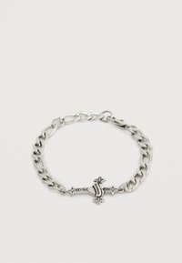 Ασημένιο βραχιόλι αλυσίδας με περίτεχνο μενταγιόν σε σχήμα σταυρού που έχει μια καρδιά και τη λέξη "Los Angeles" χαραγμένη σε λευκό φόντο.