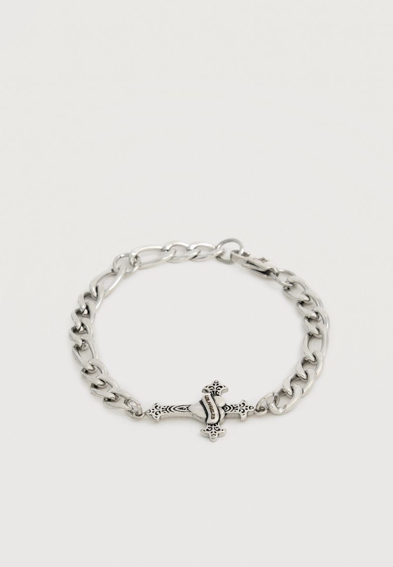 Ασημένιο βραχιόλι αλυσίδας με περίτεχνο μενταγιόν σε σχήμα σταυρού που έχει μια καρδιά και τη λέξη "Los Angeles" χαραγμένη σε λευκό φόντο.