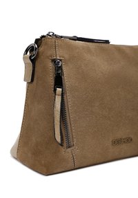 Borsa clutch in suede color sabbia con tasca laterale con zip, logo impresso e dettagli in metallo nero. Tessuto morbido con forma angolare e bordi cuciti.
