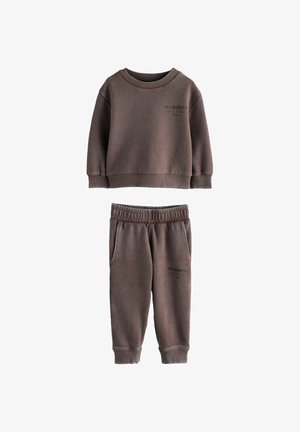 Pruun soonikuga dressipluusi ja sobivate pükste komplekt, millel on ümar kaelus, elastne vöökoht ja küljetaskud ning kummalgi osal logo detail.