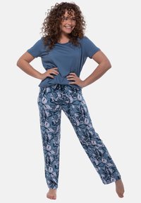 Blaues kurzärmliges Oberteil kombiniert mit pyjamahosen im Blumenmuster in Blautönen und Weiß. Die Hosen verfügen über einen elastischen Taillenbund für zusätzlichen Komfort.