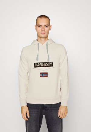 Felpa crema con coulisse grigia, caratterizzata da un'etichetta con logo nera e una piccola patch della bandiera norvegese sul davanti. Tessuto morbido, vestibilità standard.
