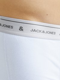 Biele bavlnené boxerky s sivým elastickým pásom, na ktorom je čiernym vytlačený nápis "JACK & JONES". Tkanina pôsobí hladko a priliehavo.