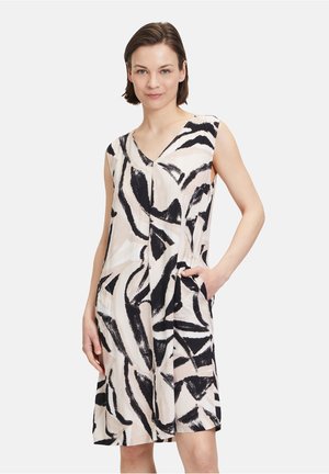 Ärmelloses Kleid aus leichtem Stoff, mit einem schwarz-creamfarbenen abstrakten Muster, V-Ausschnitt und seitlichen Taschen.
