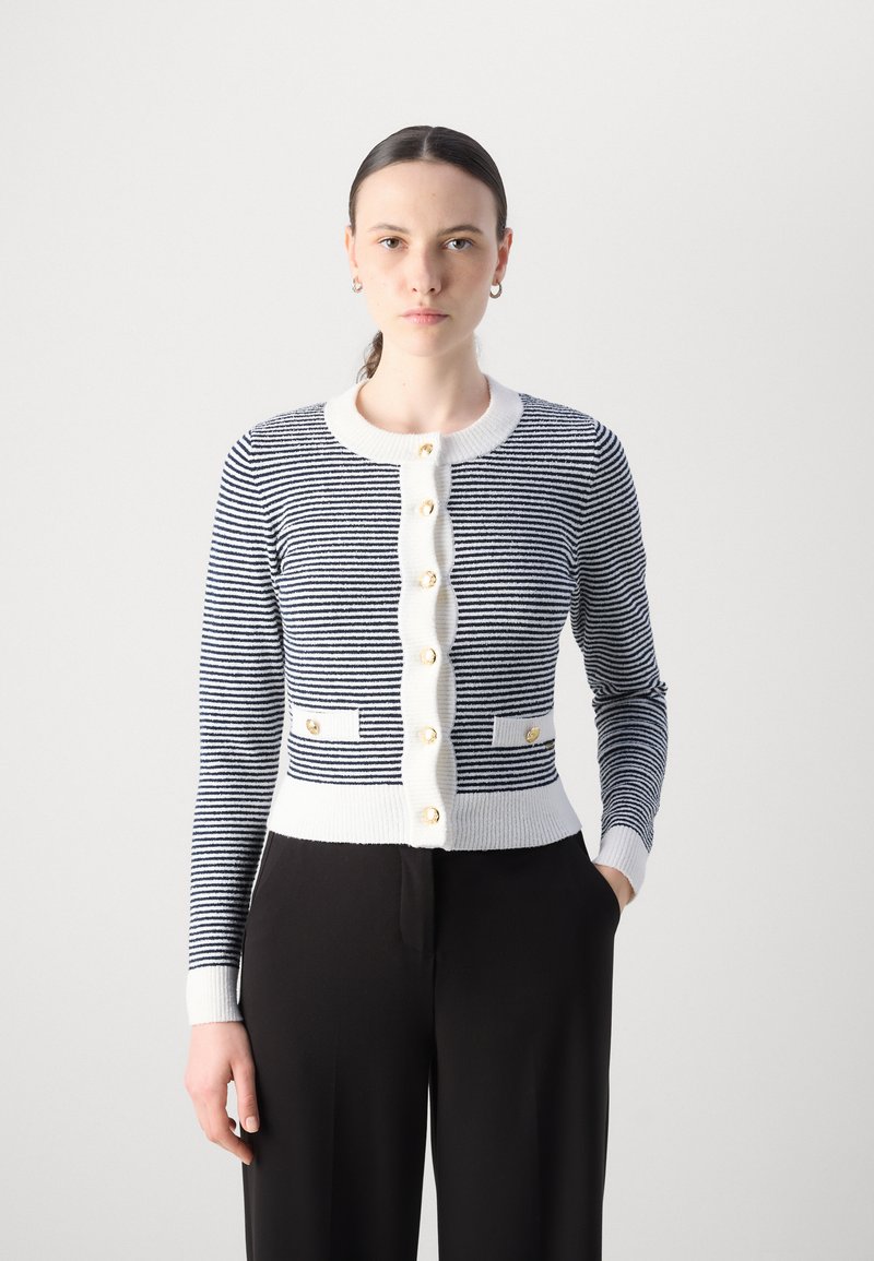 Cardigan rayé bleu marine et blanc avec des boutons dorés, texture côtelée, design ajusté et poches plaquées à la taille. Manches longues.