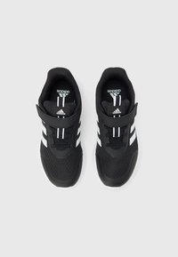 Par af sorte Adidas løbesko med hvide striber og velcrolukninger, vist ovenfra på en hvid baggrund.