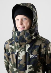 Camo-jack met hoge kraag, gemaakt van waterdicht materiaal, met een ritssluiting aan de voorkant, twee zijzakken en een logo op de borst.