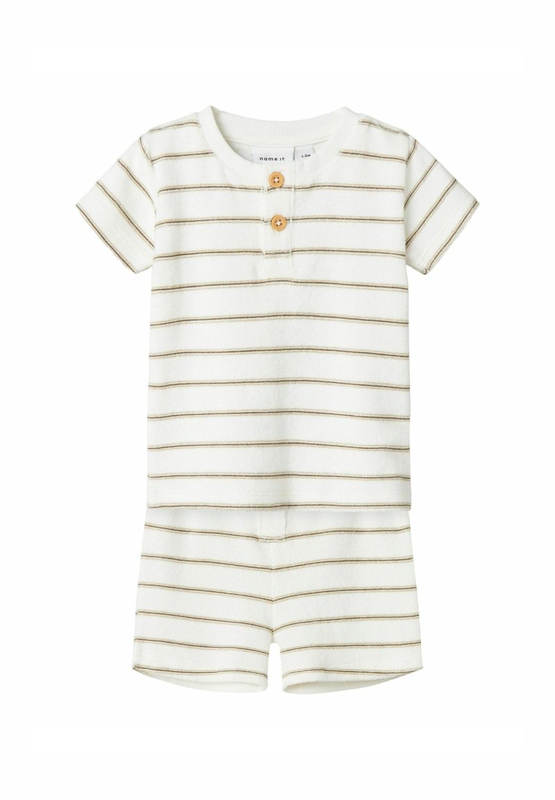 Pyjama à manches courtes, rayé en blanc et brun, avec deux boutons en bois, un col rond et un tissu doux avec une légère texture.